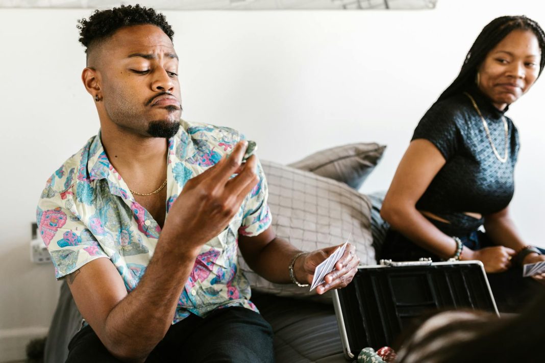 Man in Printed Shirt Holding Poker Chips and Playing Cards